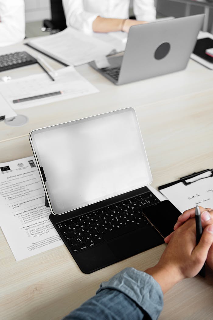 Group working together using tablets and laptops in an office setting.